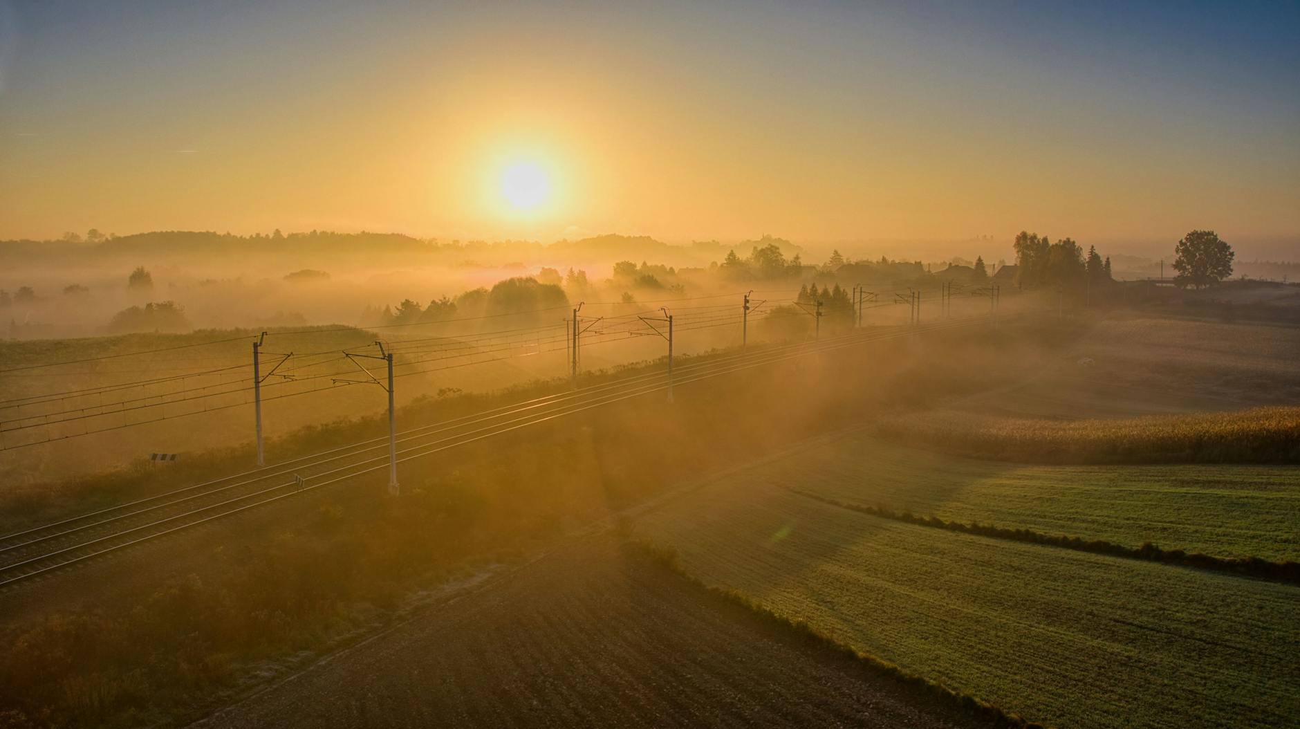 Malowniczy widok na Jedlinę-Zdrój otoczoną zielonymi wzgórzami, idealny na letni wypoczynek.